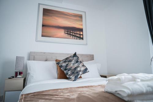 a bedroom with a bed with a picture on the wall at The Luma Suite in Albrighton