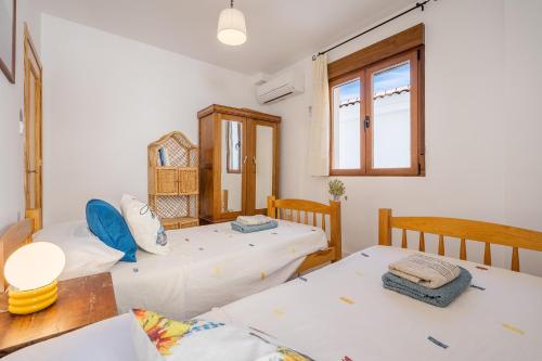 two beds in a room with a table and two chairs at Casa El Valle Verde Granada in Lecrin