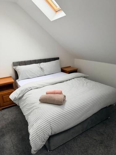 une chambre avec un lit avec une serviette rose dessus dans l'établissement Modern 3 Bed with 3 Baths and Parking, Near Centre, à Bredbury