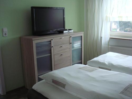 a bedroom with two beds and a television on a dresser at Ferien- Messewohnung nähe Köln-Messe Flughafen Bonn in Rösrath