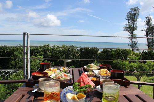 a wooden table with bowls of food on a balcony at Arimabaru Beach Resort in Motobu