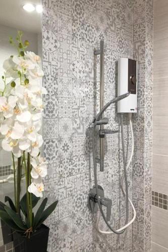 a shower with a vase of flowers in a bathroom at 51 Suanplu Residence in Bangkok