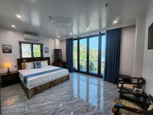 een slaapkamer met een bed en een groot raam bij Sunrise Ocean Hotel & Rooftop Bar in Cat Ba