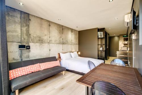 a bedroom with a bed and a couch and a table at Hidden Gem Llandudno Studio in Llandudno