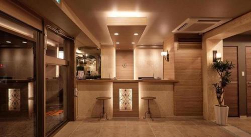 een lobby met twee krukken en een bar in een gebouw bij Ryuka Hotel Naha in Asato