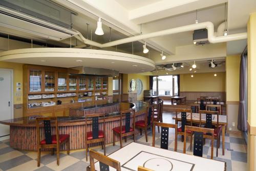 una sala da pranzo con tavoli e sedie in biblioteca di Tobi Hostel and Apartments a Shima
