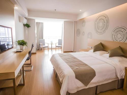 a hotel room with a large bed and a desk at GreenTree Inn Suqian Suyu District Red Star Macalline in Zhuoxu