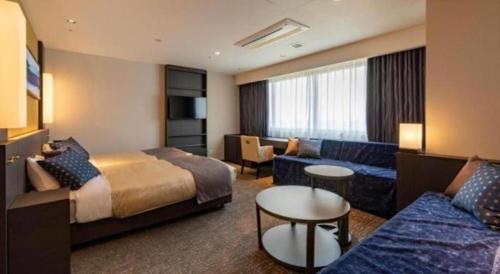 a hotel room with a bed and a couch at HOTEL BAYGULLS in Kashōji