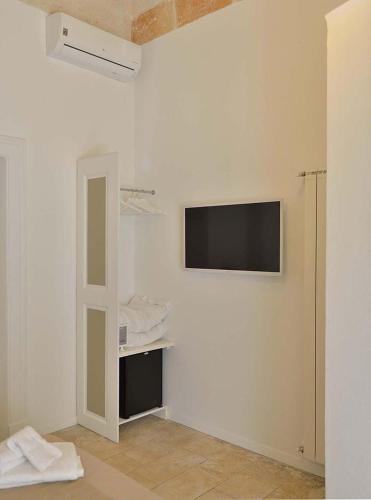 a white room with a tv on a wall at Palazzo Kapece in Monopoli