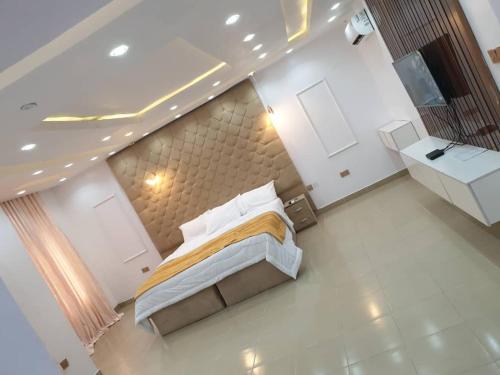 Un dormitorio con una cama en una habitación blanca. en QW5 APARTMENTS and SUITE, en Lekki