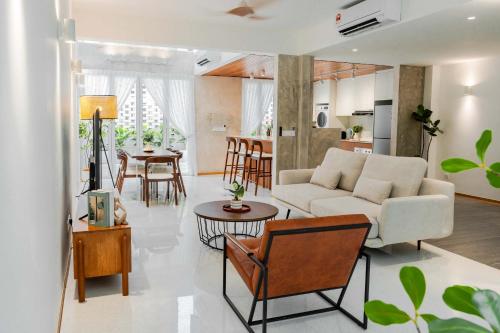 ein Wohnzimmer mit einer weißen Couch und einer Küche in der Unterkunft Terasek Terrace with Private Pool in Kuala Lumpur