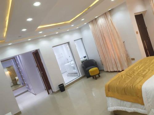 a hotel room with a bed and a yellow chair at QW5 APARTMENTS and SUITE in Lekki