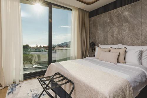 Un dormitorio con una cama y una ventana grande en Luminoso Boutique Hotel, en Budva