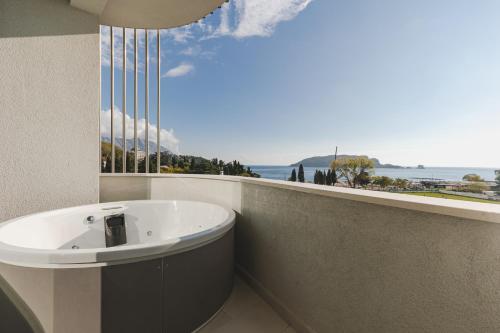 Un baño con bañera y vista al mar. en Luminoso Boutique Hotel, en Budva