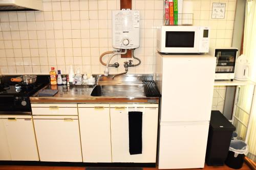 a kitchen with a sink and a microwave at cotomaro 305 -Apartment Stay Near Matsumoto Castle- in Matsumoto