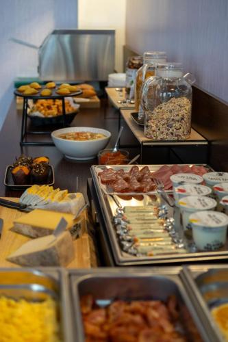 グルノーブルにあるオテル ドゥ ヨーロッパ グルノーブル ハイパーセンターのさまざまな種類の食べ物が並ぶビュッフェライン