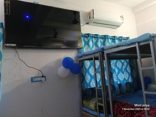a room with a bunk bed with a tv and balloons at AC Comfort Guest House in Deoghar