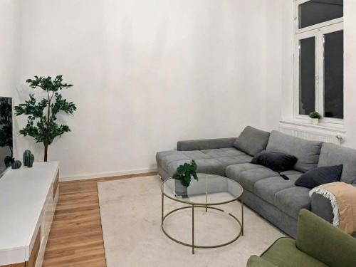 een woonkamer met een bank en een tafel bij Denkmal-Apartment zentral in Krefeld mit hohen Decken in Krefeld