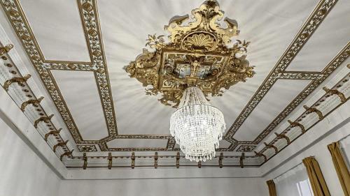 een kroonluchter aan een plafond bij Denkmal-Apartment zentral in Krefeld mit hohen Decken in Krefeld