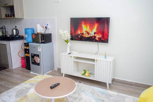 a living room with a fireplace on the wall at Stayride Homes in Ruaka
