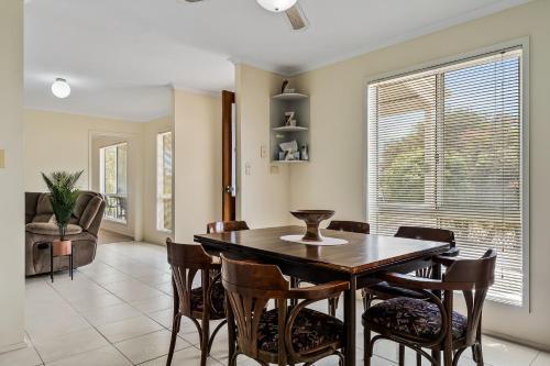 a dining room with a table and chairs at Swainson on Fontaine in Sellicks Beach