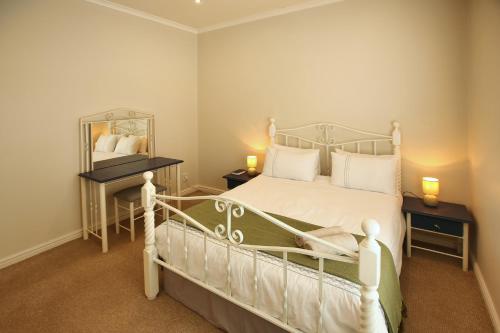 ein Schlafzimmer mit einem weißen Bett und einem Spiegel in der Unterkunft Noa Haven, Langebaan, 4 Sleeper in Langebaan