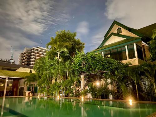 a house with a swimming pool in front of a building at ศรีย่าน เรสซิเดนซ์ Sriyan Residence in Dusit