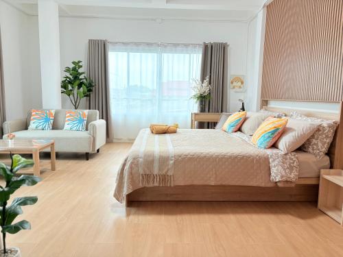 a bedroom with a large bed and a couch at Na KlongMuang I ณ คลองเมือง in Phra Nakhon Si Ayutthaya