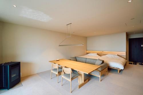a bedroom with a bed and a wooden table at SANU 2nd Home 館山1st in Tateyama