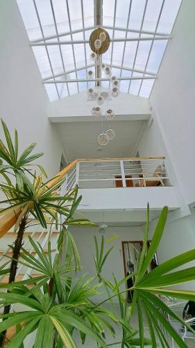 a room with plants and a ceiling with a chandelier at Na KlongMuang I ณ คลองเมือง in Phra Nakhon Si Ayutthaya