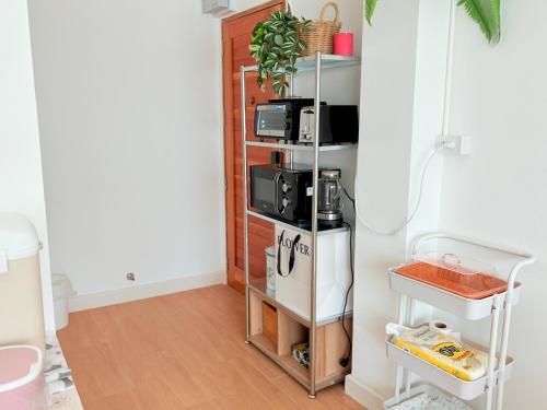 une pièce avec une étagère sur laquelle sont posés trois micro-ondes dans l'établissement Na KlongMuang I ณ คลองเมือง, à Phra Nakhon Si Ayutthaya