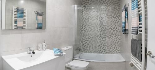 a bathroom with a sink and a toilet and a shower at SeaHomes Vacations - Cala Banys Seafront Apt & PKG in Lloret de Mar