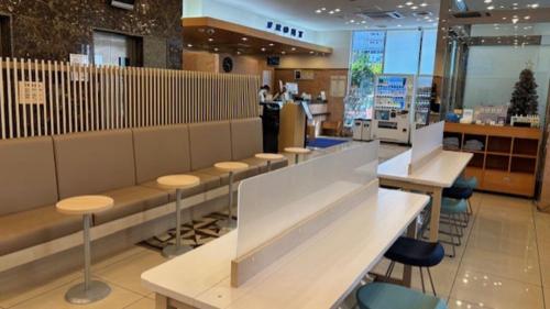 a restaurant with a row of tables and chairs at Toyoko Inn JR Yokohama sen Sagamihara Ekimae in Sagamihara
