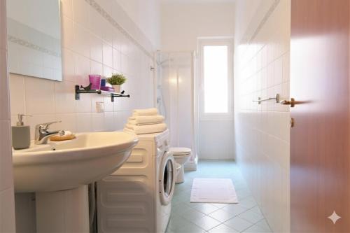 a white bathroom with a sink and a toilet at Da Simona Appartamenti in Imperia