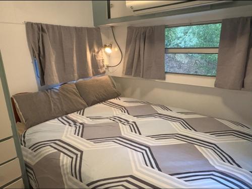 a bed in a small room with a window at Rancho Relaxo in Blackwood