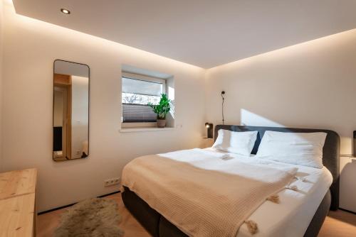 Un dormitorio con una cama grande y un espejo. en Langerwegh Apartments AP2, en Fieberbrunn