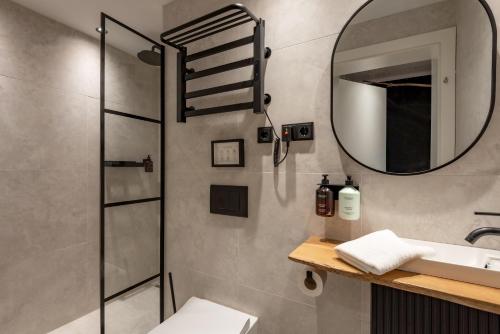 Un baño con ducha, lavabo y espejo. en Langerwegh Apartments AP2, en Fieberbrunn