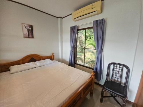 a bedroom with a bed and a window and a chair at Seaview Studio Jungle in Lamai