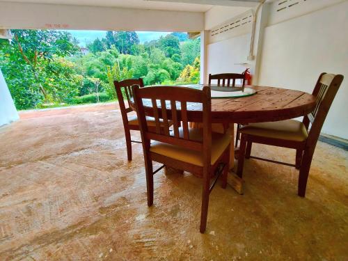 Pang MaphaGJ TOUR的一张餐桌和椅子,设有大窗户