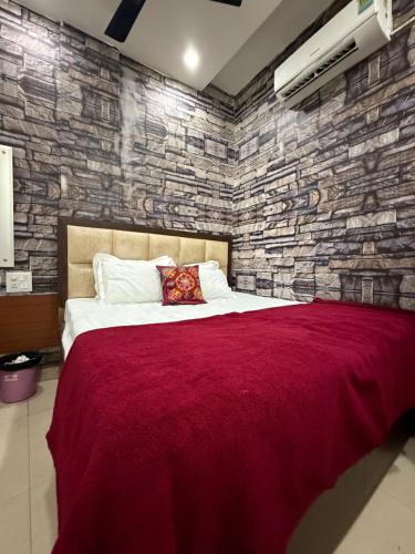 a bedroom with a large bed with a brick wall at Amritsar Backpackers Hostel in Amritsar