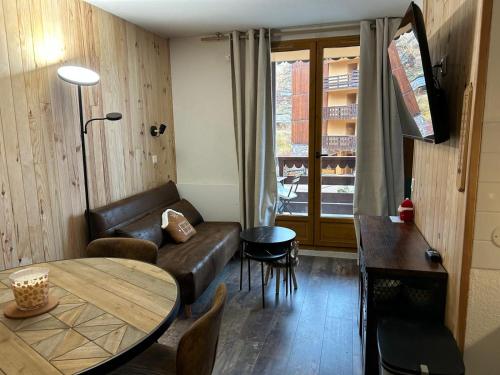 un salon avec un canapé et une table dans l'établissement appartement très chaleureux, à Risoul