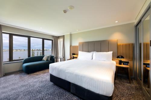 a hotel room with a large bed and a couch at Crowne Plaza Perth by IHG in Perth