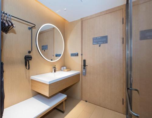 a bathroom with a sink and a mirror at JI Hotel Beijing Shangdi Nongda South Road in Beijing