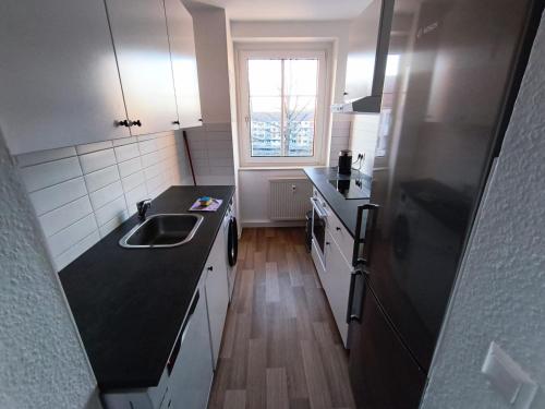 a kitchen with a sink and a black counter top at Business Apartment Chemnitz in Chemnitz