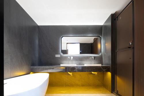 成都市にあるThe Panda Artisan, Taikoo Li Xilia Hotelの洗面台と鏡のあるバスルーム