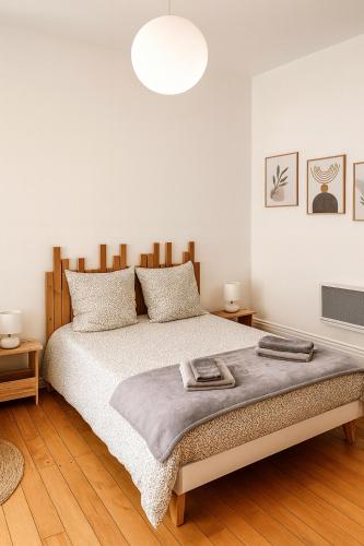 a white bedroom with a large bed and a pendant light at Studio Amboise centre historique in Amboise