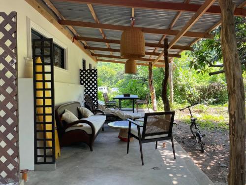 een patio met een bank en stoelen onder een pergola bij Filo La Union in San Juan