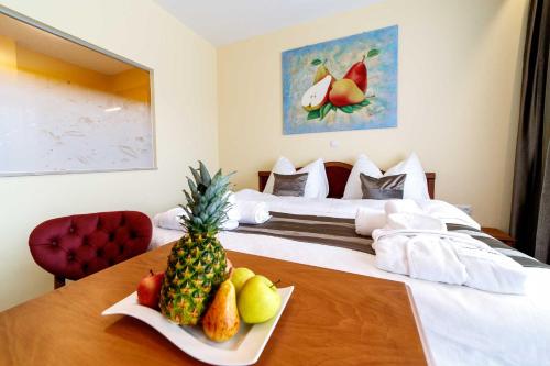 a hotel room with a bed with a table with fruit on it at VULKAN Residenz Hotel I Self Check-in in Leibnitz