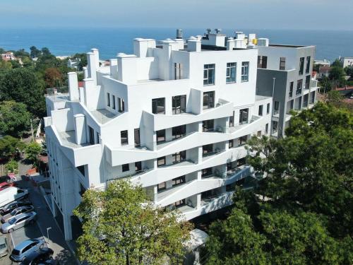 敖德萨Апартаменти Аркадія, з терасою та 3 хв до моря的一座白色的建筑,在海洋前方植有树木