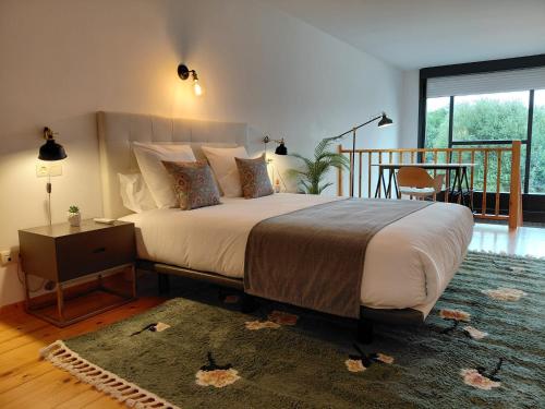 a bedroom with a large bed and a table at Apartamentos Ciudad Santiago in Santiago de Compostela